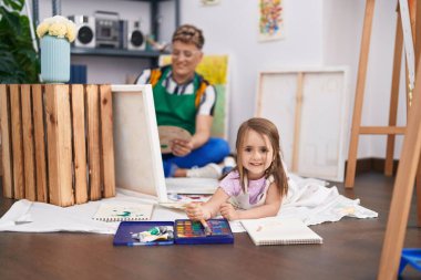 Baba ve kız sanatçılar sanat stüdyosunda kendine güvenen çizimler yapıyorlar.