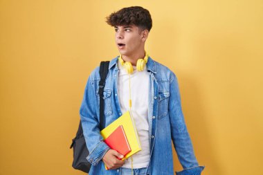 İspanyol ergen öğrenci sırt çantası takıyor ve elinde kızgın ve kızgın kitaplar tutuyordu. Öfkeli ve öfkeliydi. Öfkeyle bağırıyordu. öfke ve agresif konsept. 