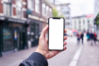 Elinde akıllı telefon tutan adam Amsterdam 'da beyaz boş ekran gösteriyor.