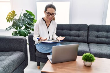 Young hispanic woman having teleconsultation psychology session at psychology clinic