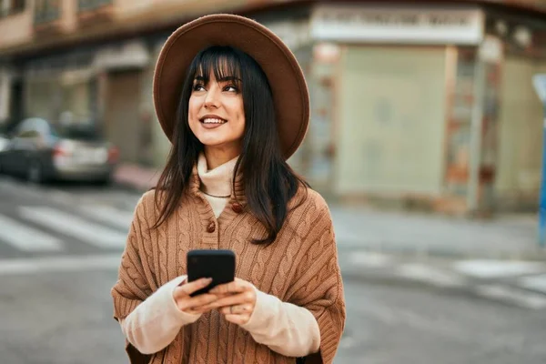 Μελαχρινή Γυναίκα Φοράει Χειμερινό Καπέλο Χαμογελώντας Χρησιμοποιώντας Smartphone Εξωτερικούς Χώρους — Φωτογραφία Αρχείου