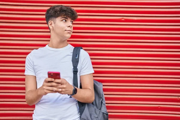 Joven Estudiante Adolescente Hispano Usando Smartphone Con Expresión Relajada Sobre —  Fotos de Stock