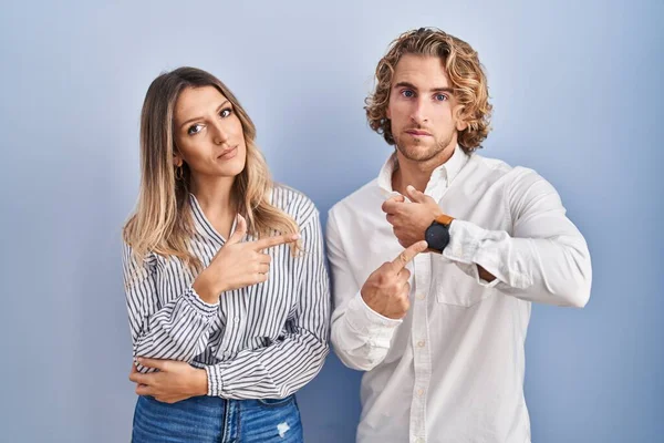 Young Couple Standing Blue Background Hurry Pointing Watch Time Impatience — Stock fotografie