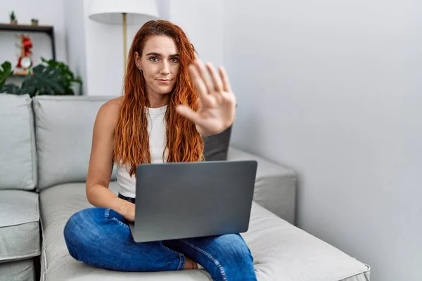 Jonge Roodharige Vrouw Met Laptop Thuis Met Open Hand Doen — Stockfoto