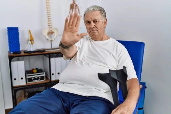 Hombre Caucásico Mayor Clínica Fisioterapia Sosteniendo Muletas Haciendo Dejar Cantar —  Fotos de Stock