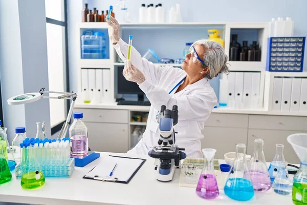 Kobieta Średnim Wieku Nosi Mundur Naukowca Patrząc Probówki Laboratorium — Zdjęcie stockowe