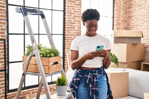 Afroamerikanerin Lächelt Neuen Zuhause Selbstbewusst Mit Smartphone — Stockfoto