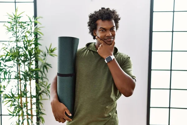 African Man Curly Hair Holding Yoga Mat Studio Looking Confident — Stockfoto