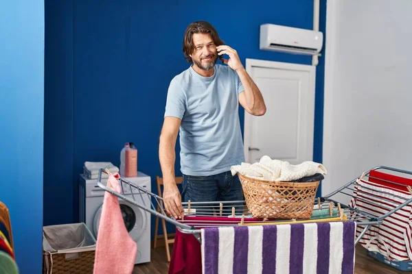 Medelålders Man Talar Smartphone Hängande Kläder Klädstreck Tvättstuga — Stockfoto