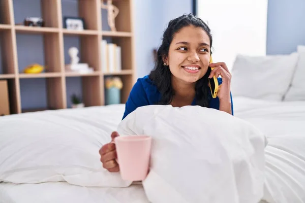 Ung Latinamerikansk Kvinna Talar Smartphone Dricka Kaffe Sovrummet — Stockfoto