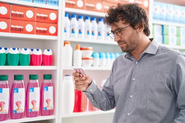 Jonge Spaanse Man Die Pillen Leest Bij Apotheek — Stockfoto