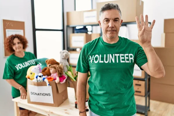 Hombre Mediana Edad Vistiendo Camiseta Voluntaria Stand Donaciones Mostrando Señalando —  Fotos de Stock