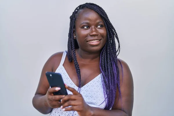 非洲裔美国妇女笑着自信地使用智能手机 而不是孤立的白色背景 — 图库照片