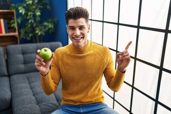 Giovane Uomo Ispanico Tenendo Mela Verde Sorridente Felice Indicando Con — Foto Stock