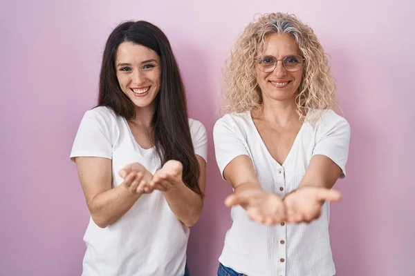 Moeder Dochter Staan Samen Roze Achtergrond Glimlachend Met Handpalmen Bij — Stockfoto