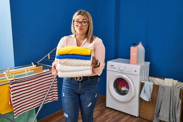 Young Hispanic Woman Holding Folded Laundry Ironing Smiling Looking Side — Stockfoto
