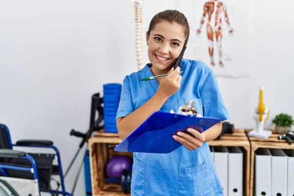 Giovane Donna Ispanica Indossa Uniforme Fisioterapia Parlando Sullo Smartphone Centro — Foto Stock