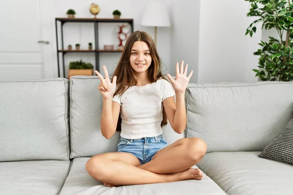 Mladá Brunetka Teenager Sedí Pohovce Doma Ukazuje Ukazuje Nahoru Prsty — Stock fotografie