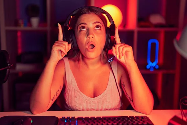 Young Blonde Woman Playing Video Games Wearing Headphones Amazed Surprised — Stock Photo, Image