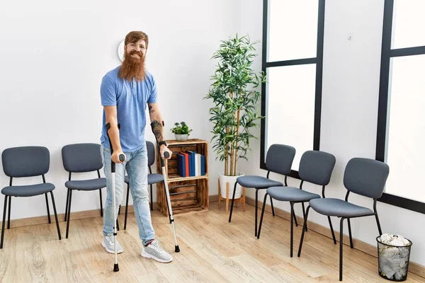 Young Redhead Man Walking Using Crutches Clinic Waiting Room — Stockfoto