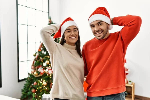 Jovem Casal Hispânico Junto Árvore Natal Sorrindo Confiante Tocando Cabelo — Fotografia de Stock