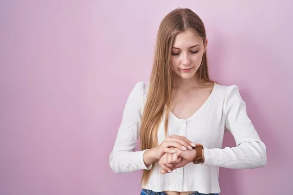 Pembe Arka Planda Duran Genç Beyaz Kadın Kol Saatindeki Saati — Stok fotoğraf