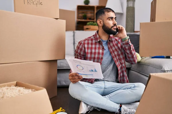 Young Hispanic Man Talking Smartphone Reading Document New Home — Stock fotografie