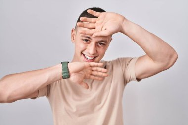 İzole edilmiş arka planda duran genç adam mutlu bir şekilde gülümsüyor ve elleriyle bir yuhalamaya bakıyor. Şaşırdım ve çıktım. 