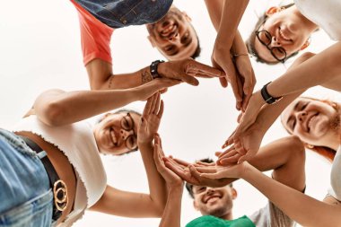 Group of young friends doing circle symbol with hands together