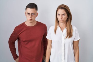 Anne ve oğlu izole edilmiş arka planda yan yana duruyorlar şüpheci ve gergin, sorun yüzünden somurtuyorlar. negatif kişi. 