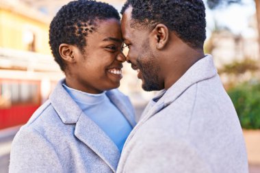 Erkek ve kadın bir arada durarak gülümsüyor.