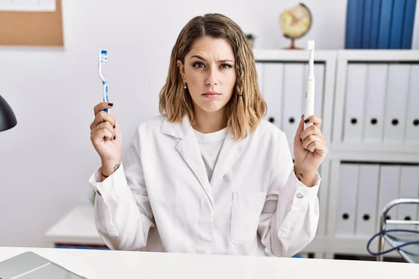 Young Hispanic Dentist Woman Holding Electric Toothbrush Teethbrush Clinic Skeptic — Photo