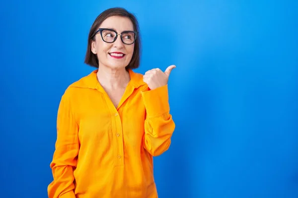 Orta Yaşlı Spanyol Kadın Mavi Arka Planda Duran Gözlüklü Mutlu — Stok fotoğraf