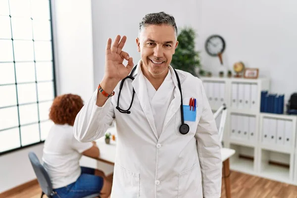 Lekarz Średnim Wieku Klinice Dodatnim Uśmiechem Pacjenta Robi Znak Ręką — Zdjęcie stockowe