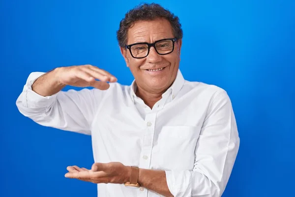 Middle Age Hispanic Man Standing Blue Background Gesturing Hands Showing — 스톡 사진