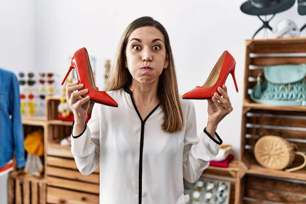 Ung Latinamerikansk Kvinna Håller Högklackade Skor Kläder Butik Puffande Kinder — Stockfoto