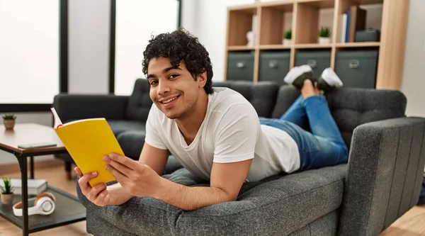 Молодий Іспаномовний Чоловік Читає Книгу Лежить Дивані Вдома — стокове фото