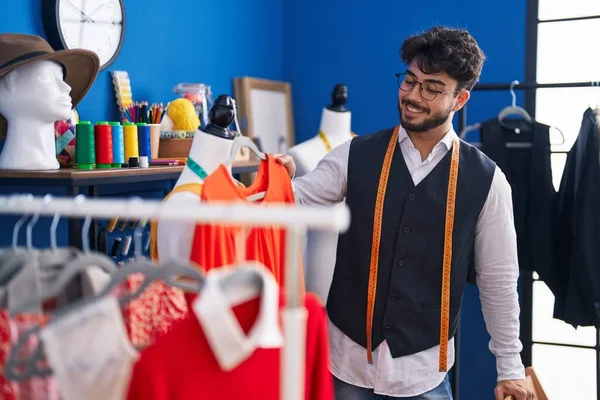 Young Hispanic Man Tailor Smiling Confident Holding Clothes Rack Sewing — Foto Stock