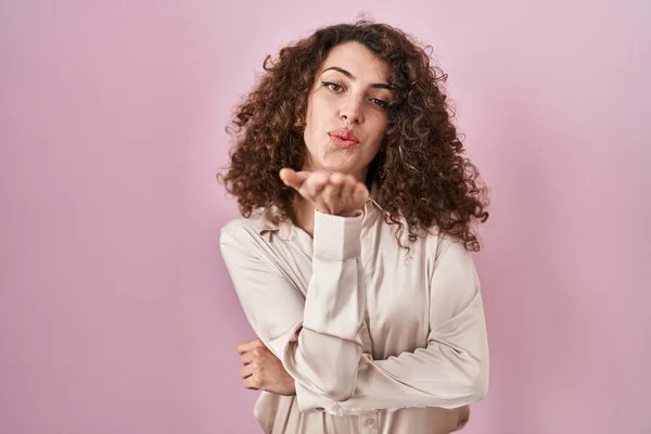 Hispanic Woman Curly Hair Standing Pink Background Looking Camera Blowing —  Fotos de Stock