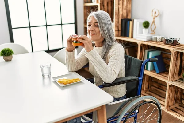 Orta Yaşlı Kır Saçlı Klasik Hamburger Yiyen Tekerlekli Sandalyede Oturan — Stok fotoğraf