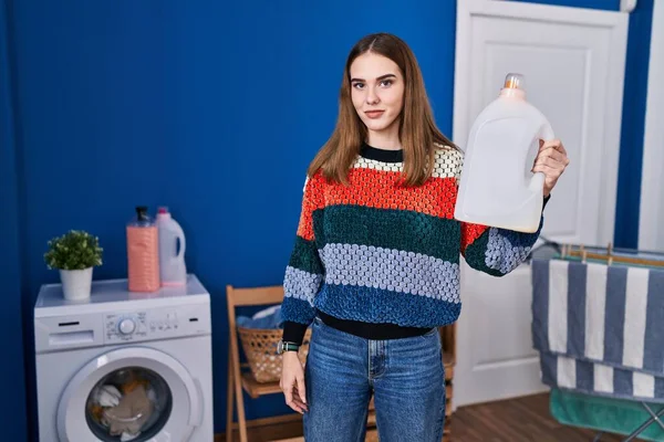 Joven Chica Hispana Sosteniendo Actitud Pensamiento Botella Detergente Expresión Sobria —  Fotos de Stock