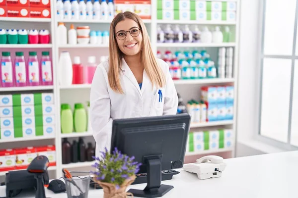年轻美丽的惊慌失措的女药剂师带着自信的笑容在药店使用电脑 — 图库照片