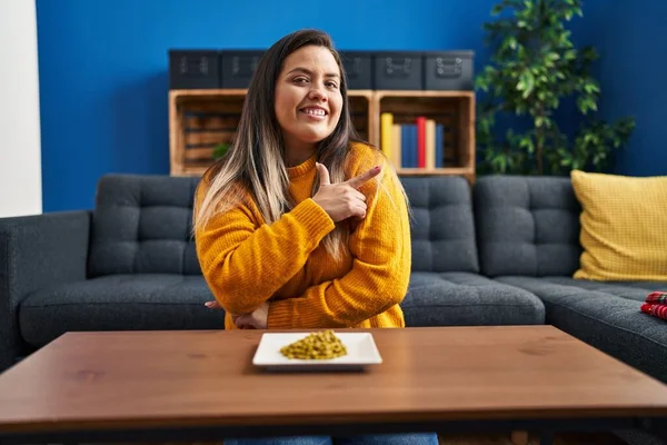 Jonge Spaanse Vrouw Eet Groene Erwten Glimlachend Vrolijk Wijzend Met — Stockfoto