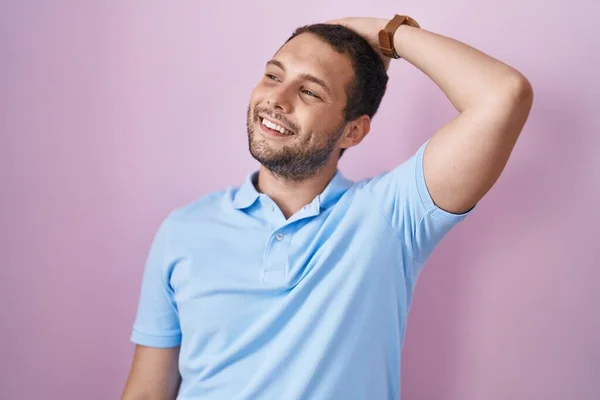 Homem Hispânico Sobre Fundo Rosa Sorrindo Confiante Tocando Cabelo Com — Fotografia de Stock