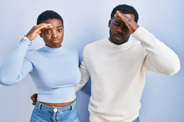 一对站在蓝色背景上的年轻的非洲裔美国夫妇担心并强调了一个手头上的问题 他们紧张而又急着要面对危机 — 图库照片