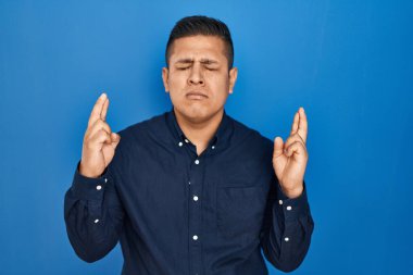 Mavi arka planda dikilen İspanyol genç adam umut ve gözlerin kapalı gülümseyerek bana işaret etti. Şans ve batıl inançlar. 