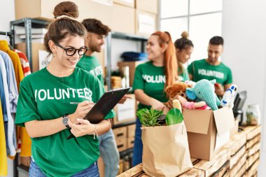 Group of young volunteers smiing happy working at charity center.