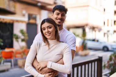 Mand and woman couple hugging each other at street