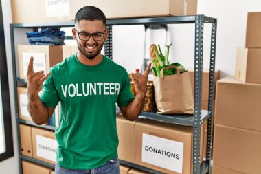 Genç Hintli gönüllü bağış kutusu tutuyor çılgın bir ifadeyle bağırıyor elleri havada rock sembolü yapıyor. Müzik yıldızı. ağır kavram. 