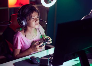 Oyun odasında joystick kullanarak video oyunu oynayan tapılası İspanyol kız flaması.